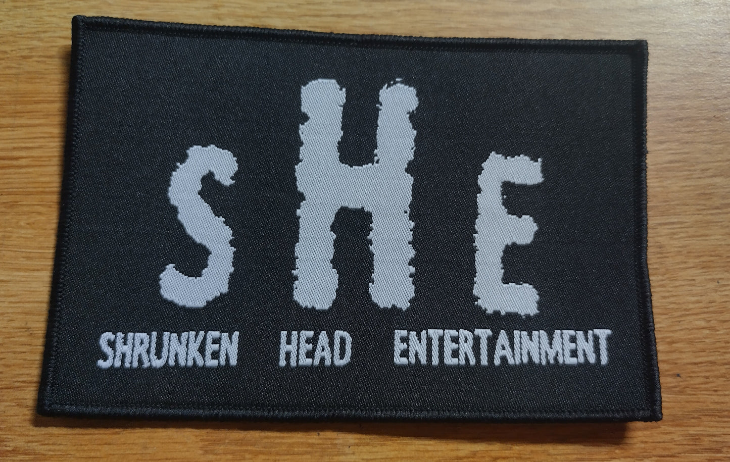 Shrunken Head Ent logo Black border Woven Patch